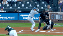 a baseball game is being played in front of a sign that says coors