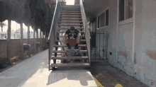 a man wearing a shirt that says los angeles sits on the stairs