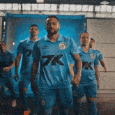a group of soccer players in blue uniforms with 7k on the front