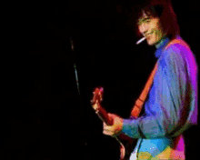a man playing a guitar and smoking a cigarette