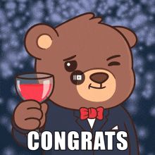 a teddy bear in a suit and bow tie holding a glass of wine with the words congrats below him