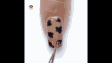 a close up of a nail being painted with a brush