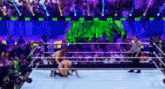 a man is kneeling in a wrestling ring while a referee looks on .