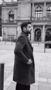 a black and white photo of a man standing in front of a building that has the word orl on it