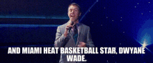 a man and a woman standing on a stage with the words and miami heat basketball star dwyane wade