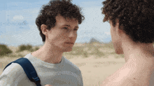 a man with a blue backpack looks at another man