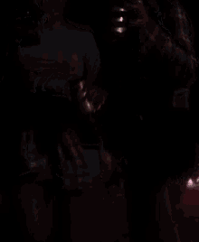 a woman in a coca cola shirt is dancing in the dark .