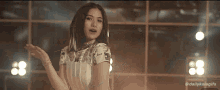 a woman in a white dress is dancing in front of a window with the hashtag dailykaiagifs on the bottom