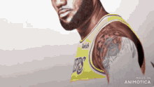 a man with a tattoo on his arm is wearing a yellow lakers jersey