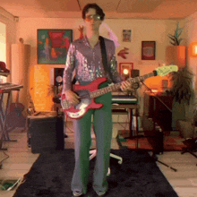 a man in a sequined shirt is holding a red guitar