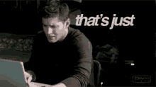 a man is sitting at a desk with a laptop and the words that 's just sick behind him
