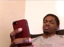 a man sitting on a couch looking at a cell phone
