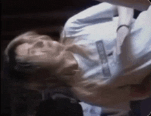 a man in a white shirt is laying on his back with his head down .