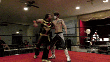 a man with a tattoo on his chest is wrestling another man in a ring