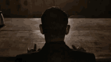 the back of a man 's head is shown in a dark room