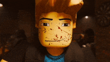 a close up of a lego man 's face with blood spots on it