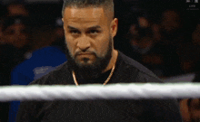 a man with a beard is standing in a boxing ring with the word live on the screen