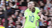 a soccer player wearing a number 10 jersey is being hugged by another player