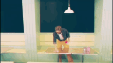 a man is cleaning a table in a diner with cmh written on the bottom