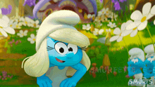 a smurf is standing in a field of flowers with the word smurfs on the bottom