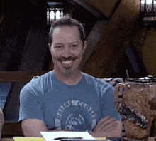 a man wearing a blue shirt with the word cloth on it smiles for the camera