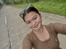 a woman wearing sunglasses is taking a selfie on the road