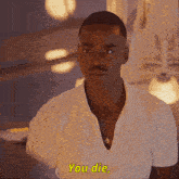 a man in a white shirt says you die in yellow letters
