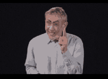 a man with fake eyebrows and a bow tie is pointing at something