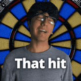 a man in front of a dart board with the words that hit
