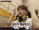 a man wearing headphones with korean writing on the bottom right