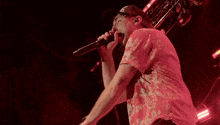 a man singing into a microphone wearing a hat that says ' nyc ' on it