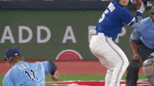 a baseball player in a blue uniform with the number 11 on his back
