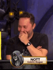 a man is laughing with a sign that says " nott goblin rogue "