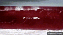 a red wave in the ocean with the words welcome written in white