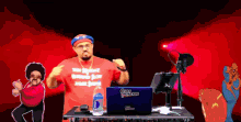 a man wearing a red shirt that says " the biggest reward ever " is standing in front of a go racer laptop