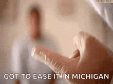 a close up of a person holding a syringe with the words got to ease it in michigan written on it