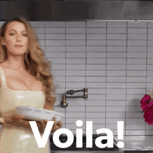 a woman in a kitchen with the word voila written in white