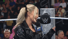 a woman in a wrestling ring with a hat that says w