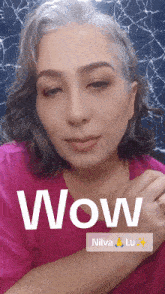 a woman with gray hair is wearing a pink shirt with the word wow on it