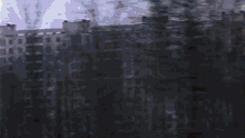 a blurry picture of a building with trees in the foreground