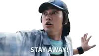 a man wearing a hat and a shirt says " stay away "