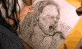 a person is drawing a picture of a man singing into a microphone with the word korn written on it .