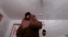 a blurry picture of a person standing in a room with a bottle on the wall .