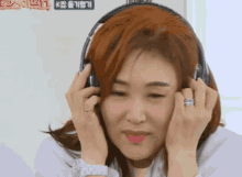 a woman wearing headphones with a green sign that says k