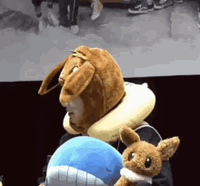 a person wearing a teddy bear costume is holding a stuffed animal .