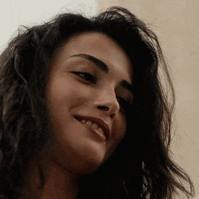 a close up of a woman 's face with a slight smile