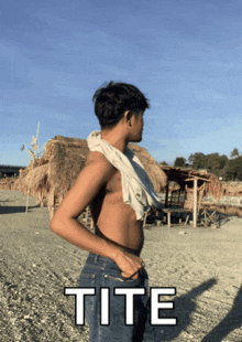 a shirtless man standing on a beach with the word tite written below him