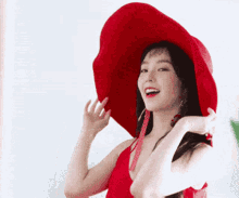 a woman wearing a red hat and a red top is smiling .