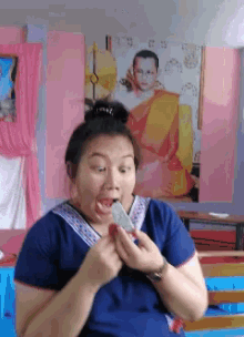a woman is making a funny face in front of a painting of a man