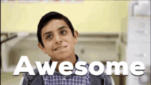 a young boy is smiling in front of an awesome sign
